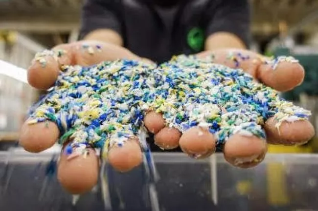 A close up of a student's hands holding plastic pellets